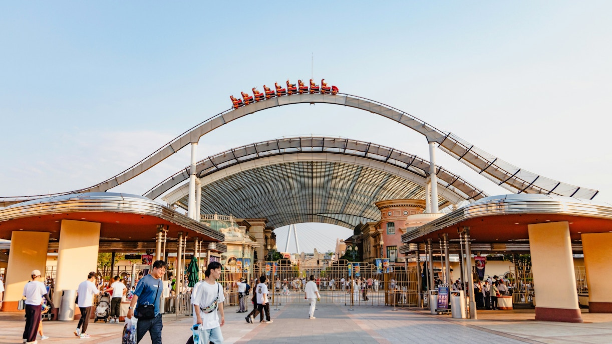 Entrance to Universal Studios Japan with roller coaster track overhead.