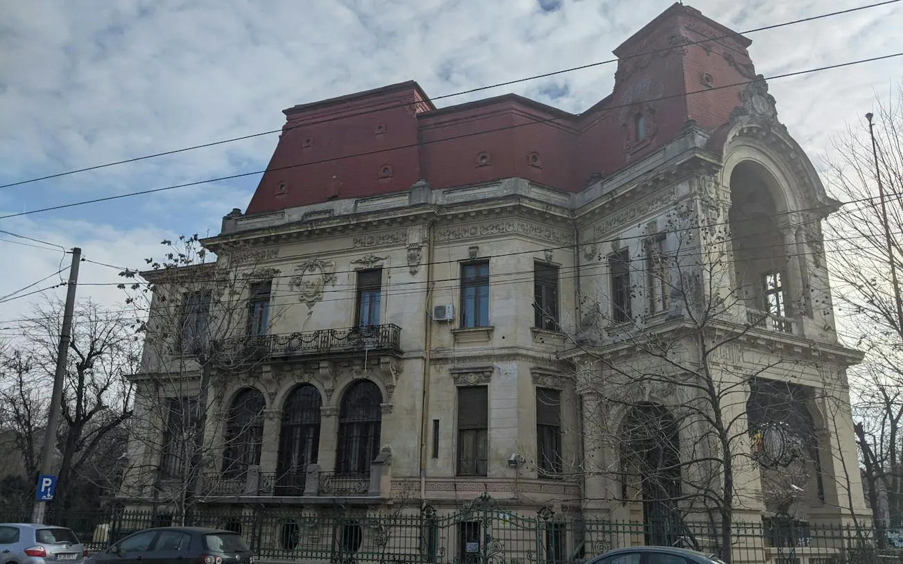 Historic building with ornate architecture in Bucharest, part of the Theatrical Odyssey city exploration game.
