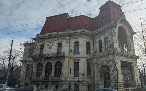 Historic building with ornate architecture in Bucharest, part of the Theatrical Odyssey city exploration game.