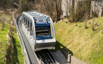 Nordkettenbahn funicular ascending through forested area in Innsbruck.