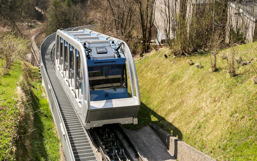 Nordkettenbahn funicular ascending through forested area in Innsbruck.