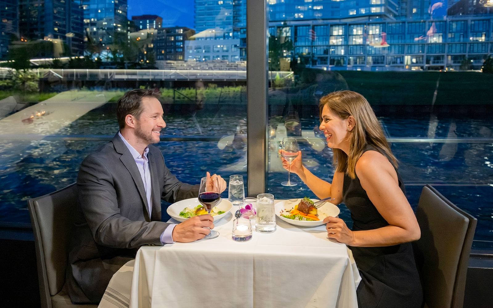 Couple dining on a Chicago river cruise with city skyline view.