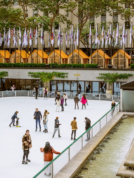 Tourists ice skating at The Rink in Rockefeller Center, New York City.