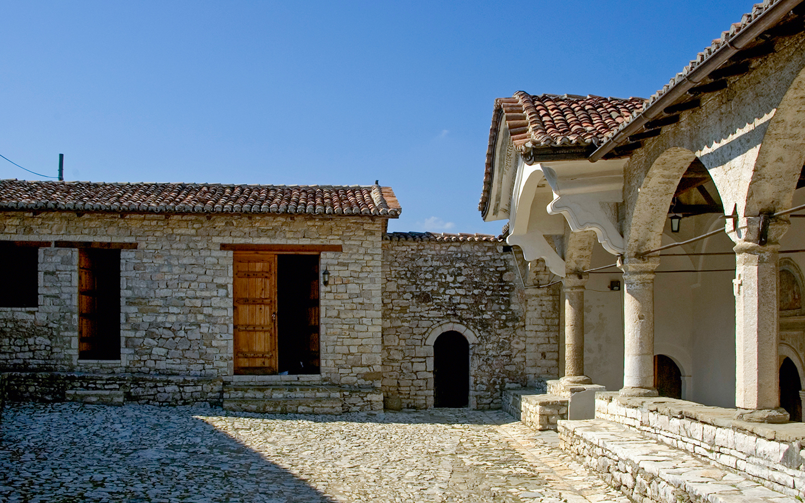 Exterior of Onufri National Iconographic Museum in Berat with stone walls and arched entrance.