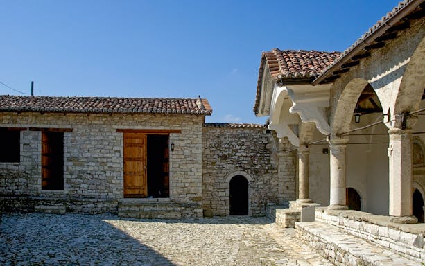 Exterior of Onufri National Iconographic Museum in Berat with stone walls and arched entrance.