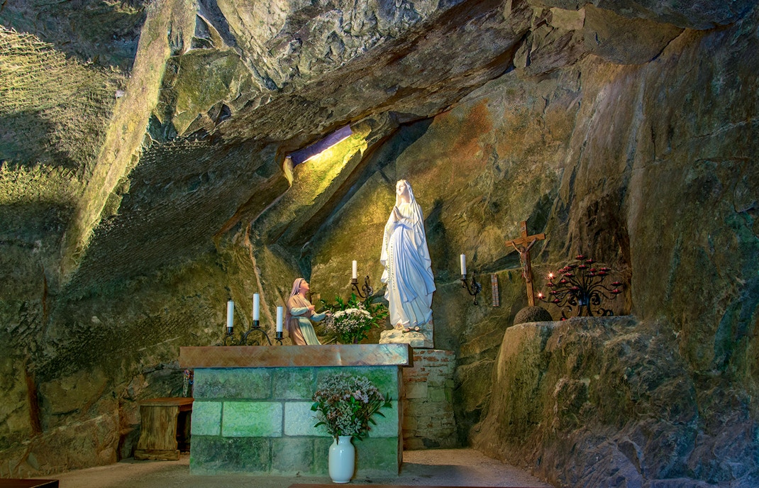Underground Naples worship place with ancient stone arches and dimly lit passageways.