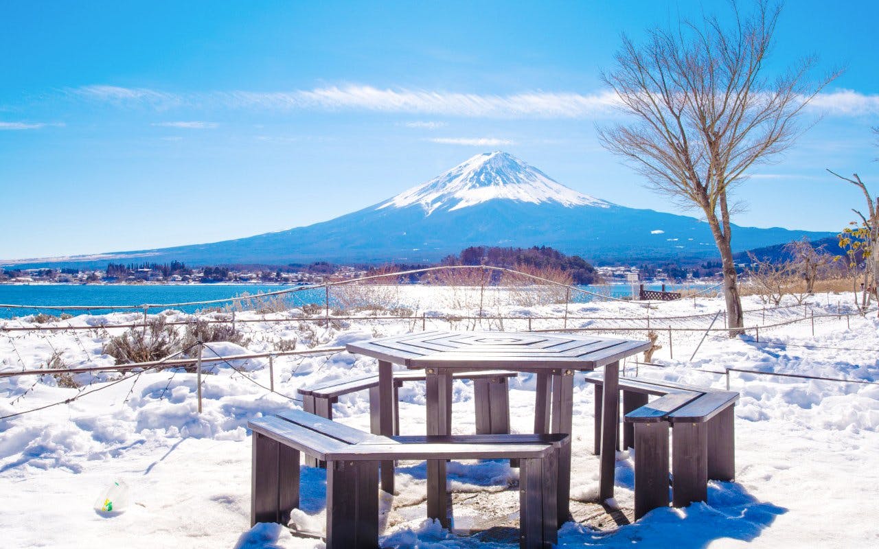 Mount Fuji in winter with snow-covered picnic area at Lake Kawaguchiko.