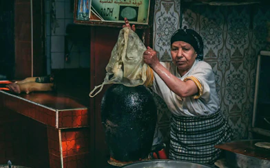 Artisan preparing traditional goods in Fes souk during city tour.