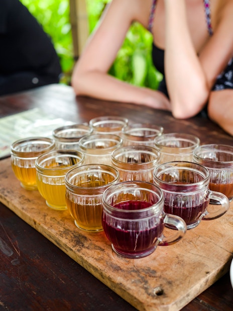 Coffee tasting session with various brews on a wooden tray in Bali.