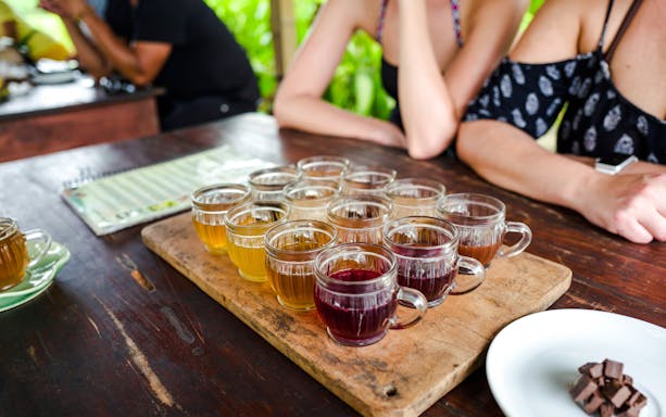 Coffee tasting session with various brews on a wooden tray in Bali.