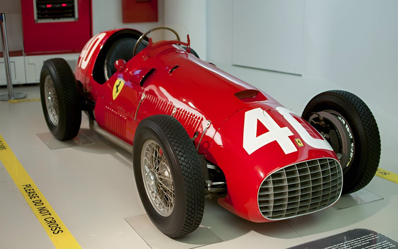 Historic Ferrari race car with number 40 on display in a museum.