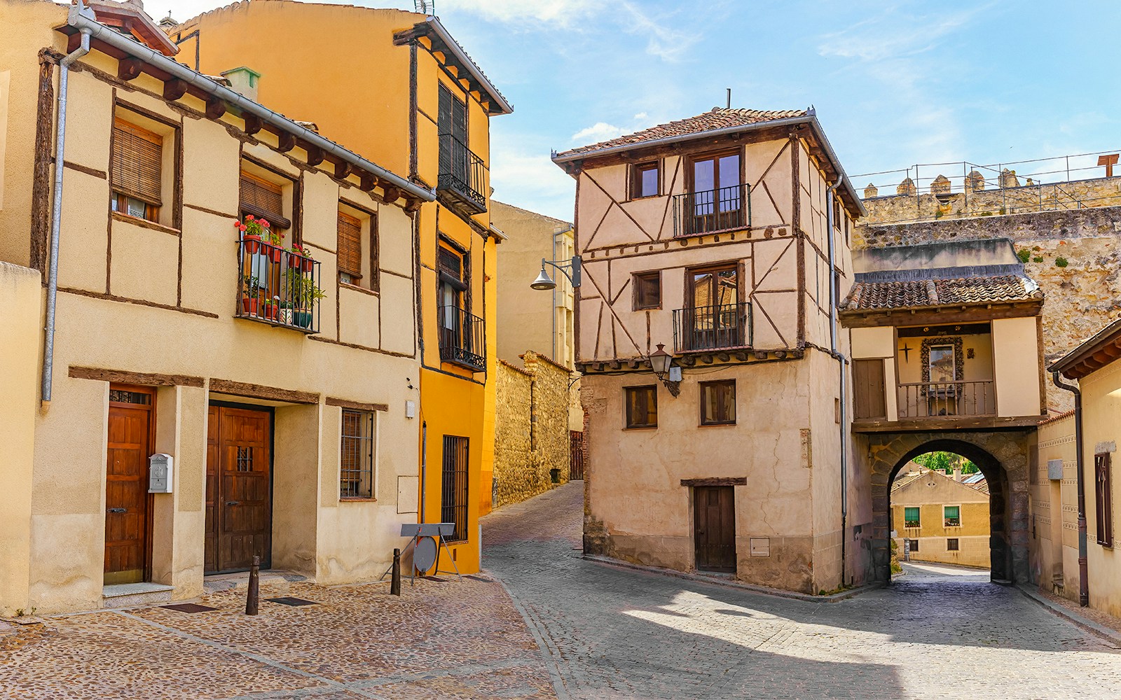 Segovia Jewish Quarters street view with historic stone buildings and narrow cobblestone path.