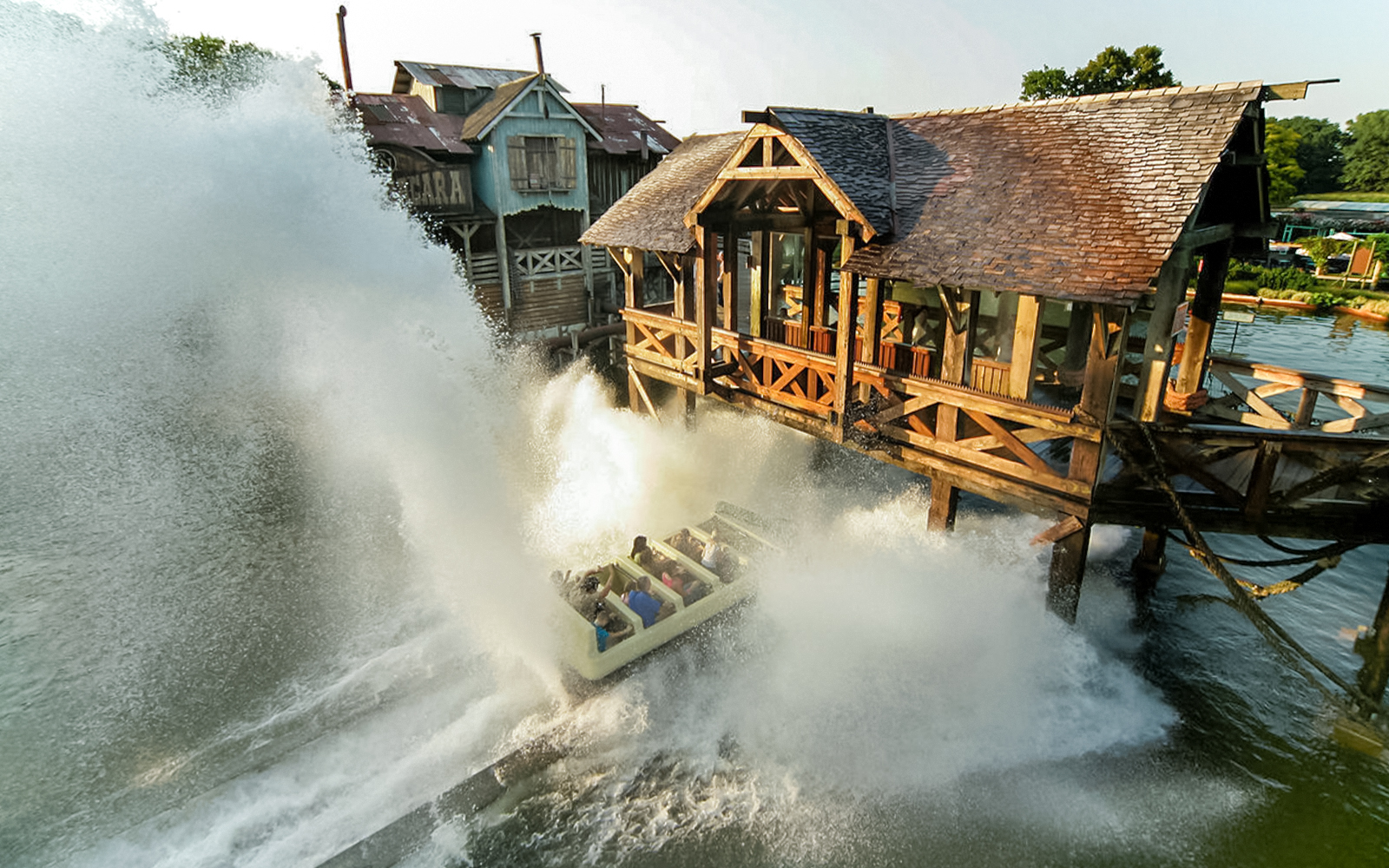 Manège Camo Niagara au parc Bellewaerde avec éclaboussures d'eau et cavaliers en mouvement.
