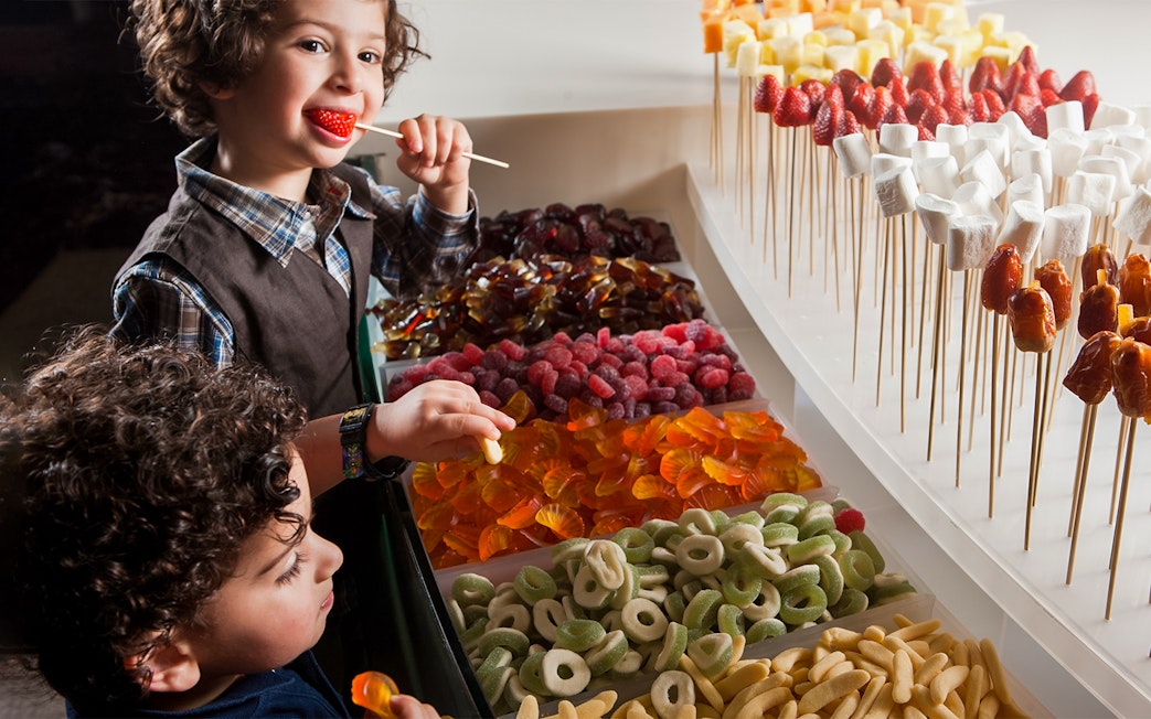 Children enjoying candy at a dessert buffet, Atlantis the Palm, Dubai.