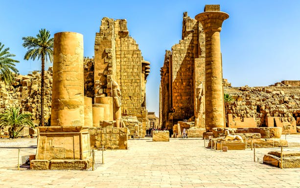 Ancient ruins with columns and statues in Luxor's Valley of the Queens.