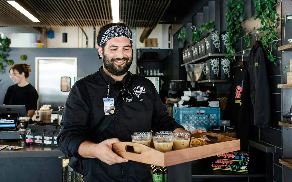 Tour guide serving coffee samples during VIP Morning Market Experience.