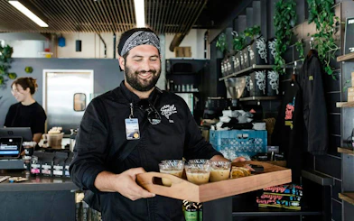 Tour guide serving coffee samples during VIP Morning Market Experience.