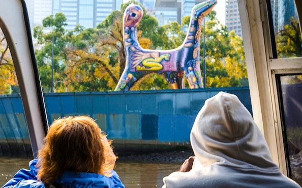 Passengers view colorful sculpture from Melbourne Yarra River cruise.