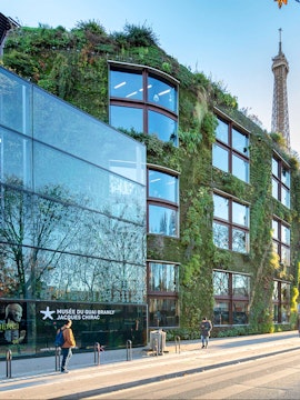 Musée du Quai Branly exterior with vertical garden and Eiffel Tower in Paris.