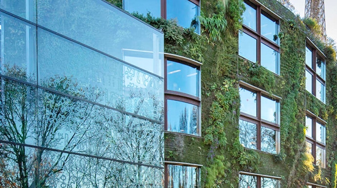 Musée du Quai Branly exterior with vertical garden and Eiffel Tower in Paris.