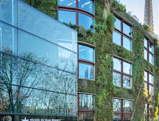 Musée du Quai Branly exterior with vertical garden and Eiffel Tower in Paris.