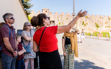 Guide explaining to tourists at the Tower of Pisa Complex.
