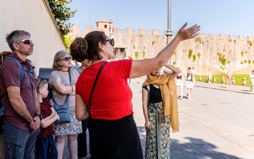 Guide explaining to tourists at the Tower of Pisa Complex.