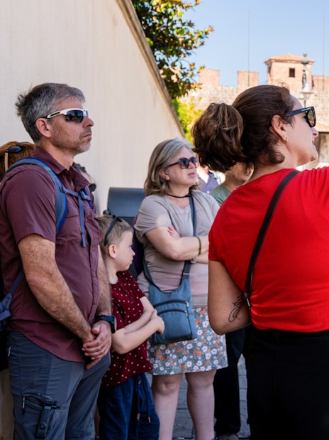 Guide explaining to tourists at the Tower of Pisa Complex.