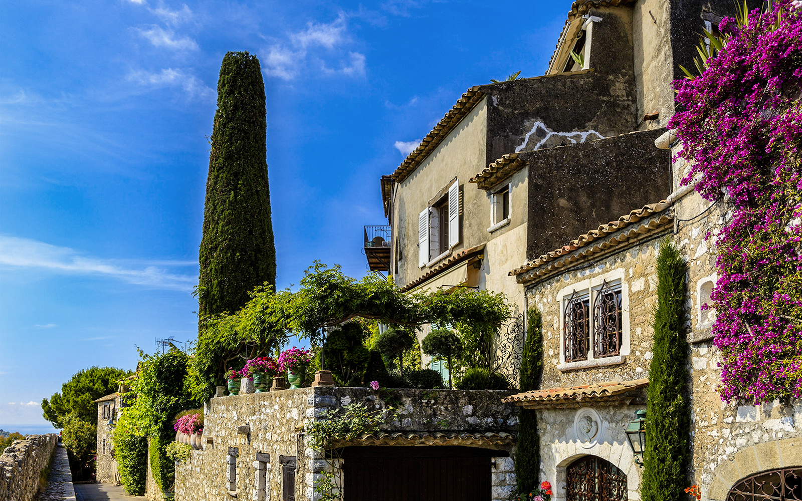 Stone house with flowers and greenery in Saint Paul de Vence, France.