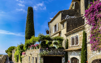 Stone house with flowers and greenery in Saint Paul de Vence, France.