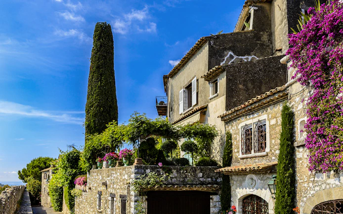 Stone house with flowers and greenery in Saint Paul de Vence, France.