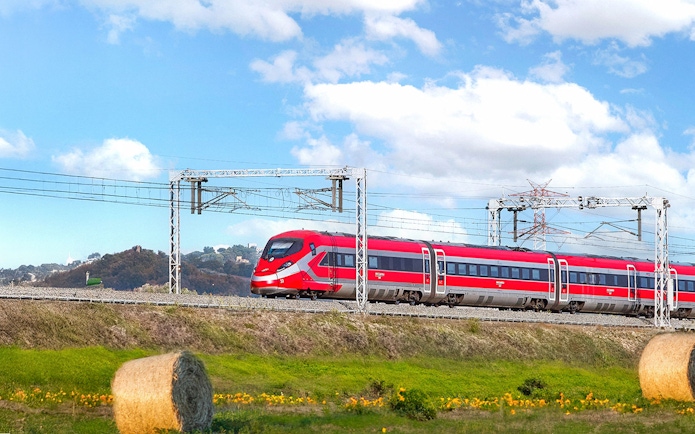 Trenitalia high-speed train traveling through Italian countryside.