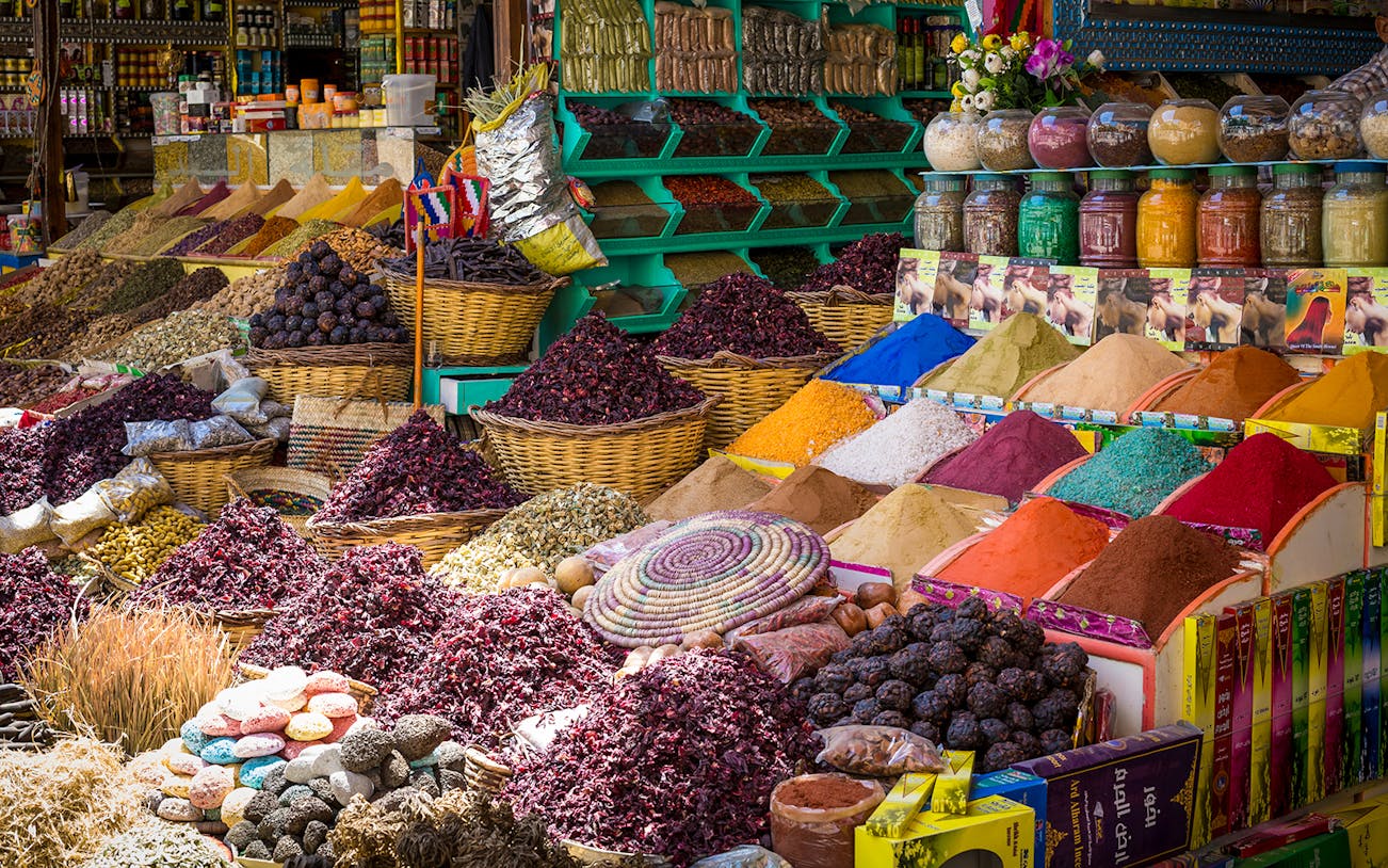 Colorful spices and herbs displayed in baskets at Khan el-Khalili market, Cairo.