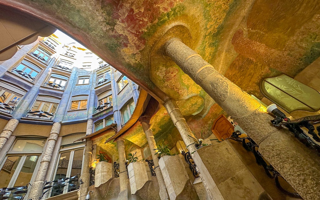 Casa Mila courtyard with colorful ceiling and spiral stair, Barcelona.