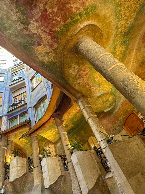 Casa Mila courtyard with colorful ceiling and spiral stair, Barcelona.