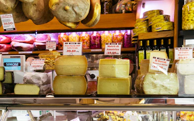 Cheese and cured meats display at a Bologna deli during a guided food tour.