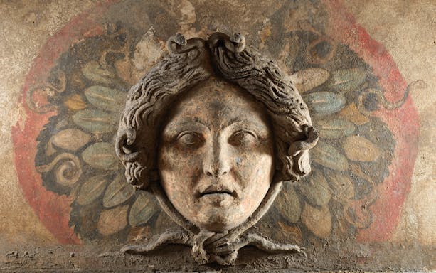 Ancient stone face carving at Ipogeo dei Cristallini, Naples.