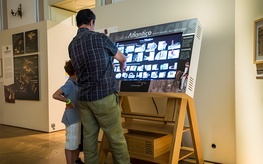 Visitors interacting with a digital display at Leonardo3 Museum, Milan.