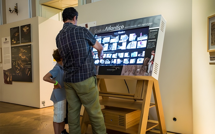 Visitors interacting with a digital display at Leonardo3 Museum, Milan.
