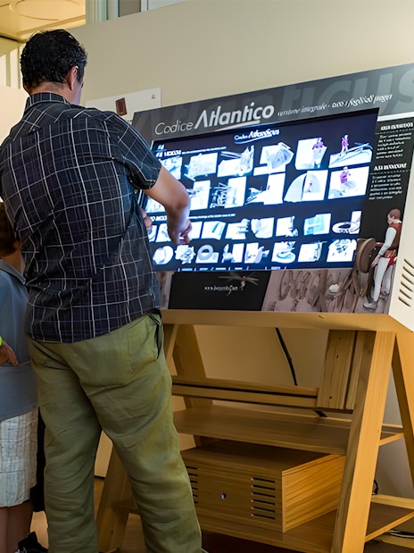 Visitors interacting with a digital display at Leonardo3 Museum, Milan.