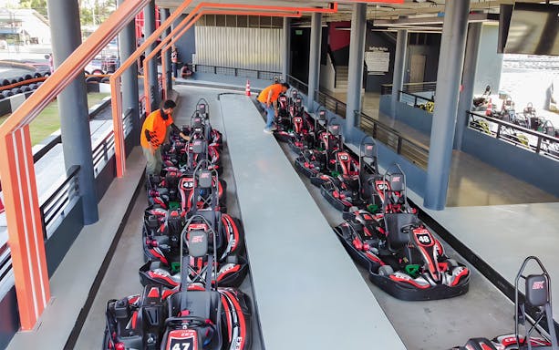 Gokarts lined up at outdoor track in Thepprasit Pattaya, staff preparing for race.