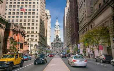 Philadelphia City Hall viewed from a busy street in Old Town, part of a self-guided exploration game.