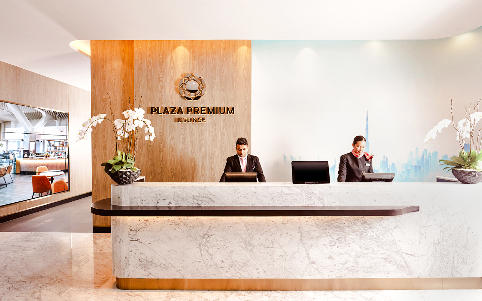 Plaza Premium Lounge reception at Dubai International Airport with staff at the counter.
