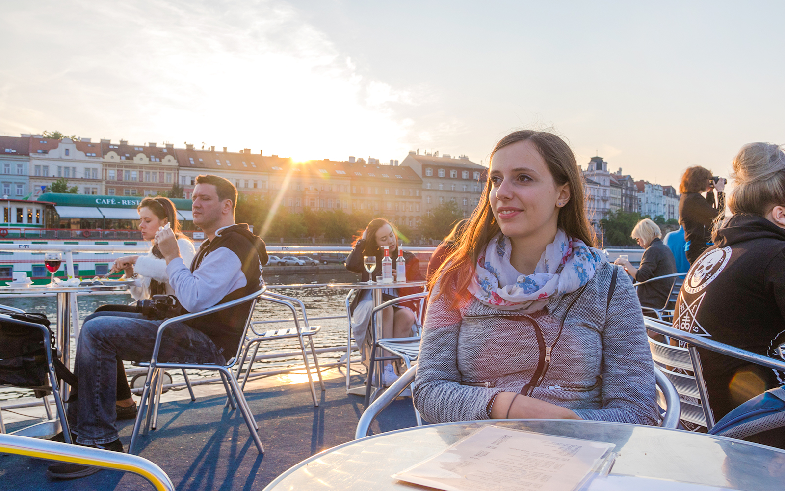 Woman enjoying a sunset cruise on the Vltava River in Prague.