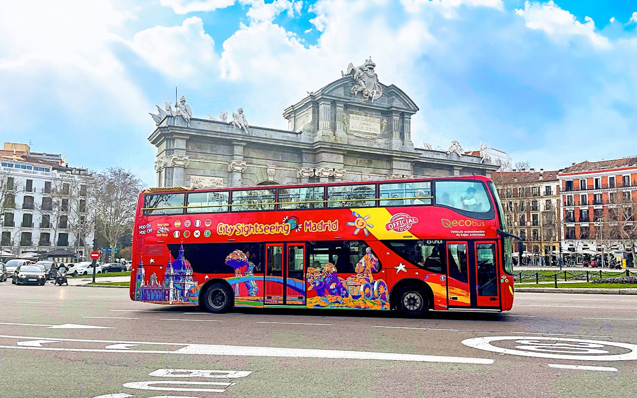 Citysightseeing bus in front of Puerta de Alcalá, Madrid.