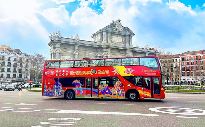 Citysightseeing bus in front of Puerta de Alcalá, Madrid.