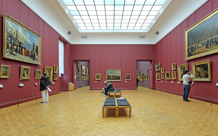 Tour guide pointing out artwork to a group during a Skip-the-Line guided tour at the Louvre Museum in Paris.