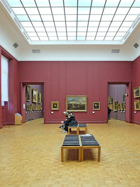 Tour guide pointing out artwork to a group during a Skip-the-Line guided tour at the Louvre Museum in Paris.