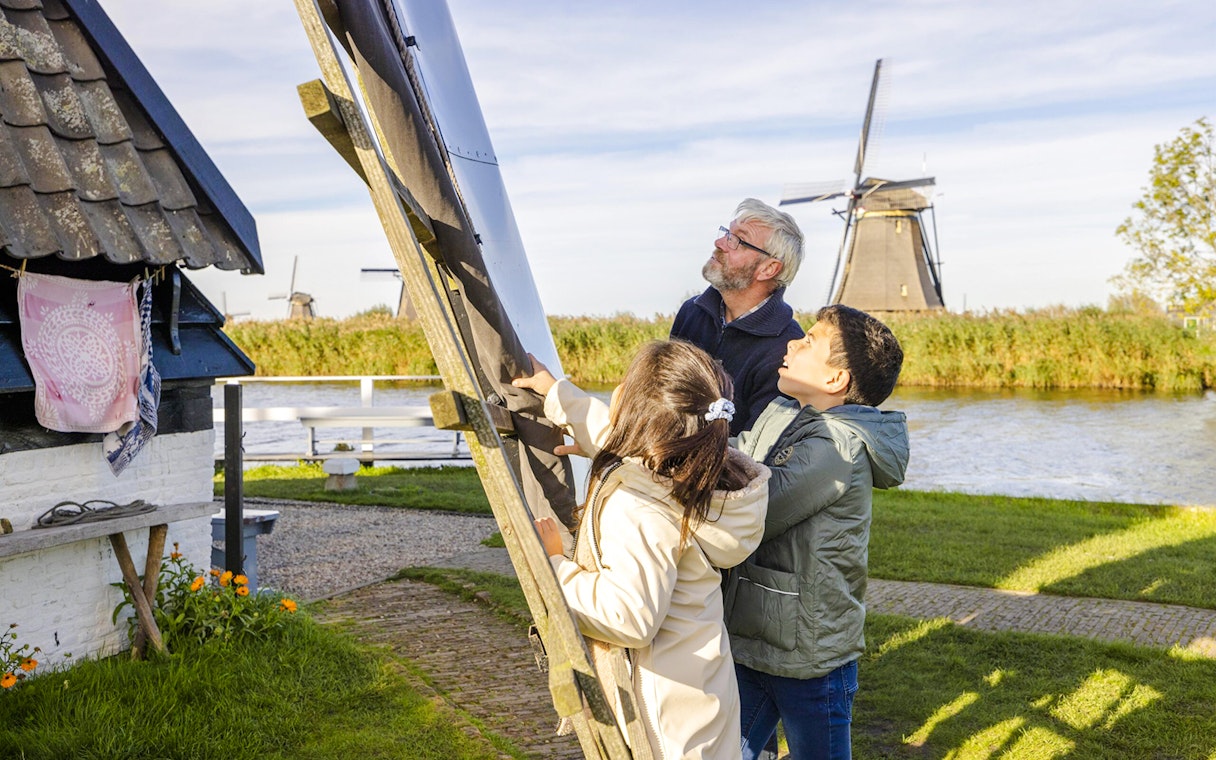 Visitors examining windmill blades at Blokweer Museum Mill, Kinderdijk.