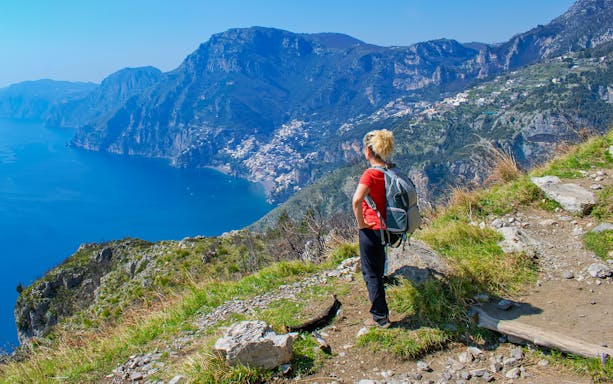Hiker overlooking Amalfi Coast on Sentiero degli Dei trail, Italy.